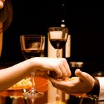 Man and woman at the restaurant - holding hands together